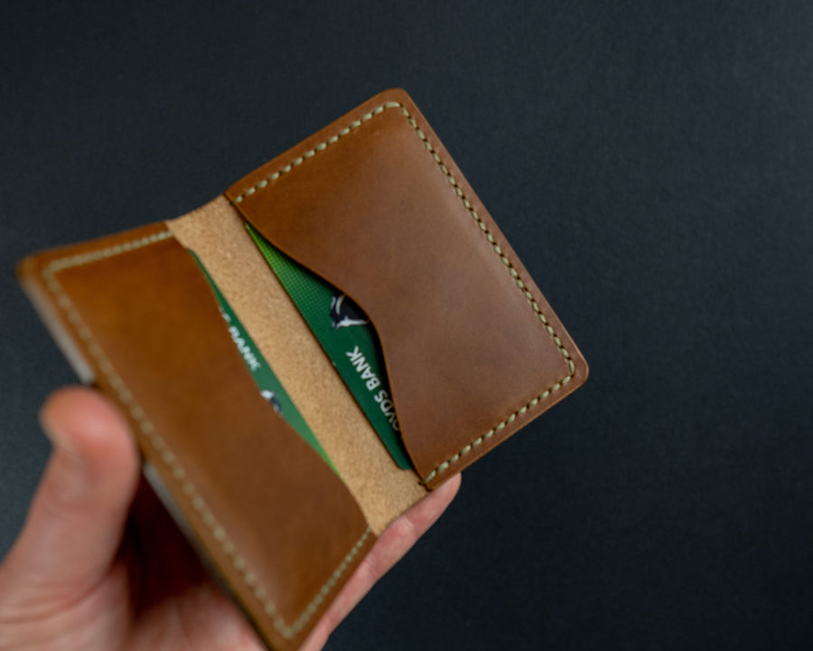 tan leather wallet with green thread
