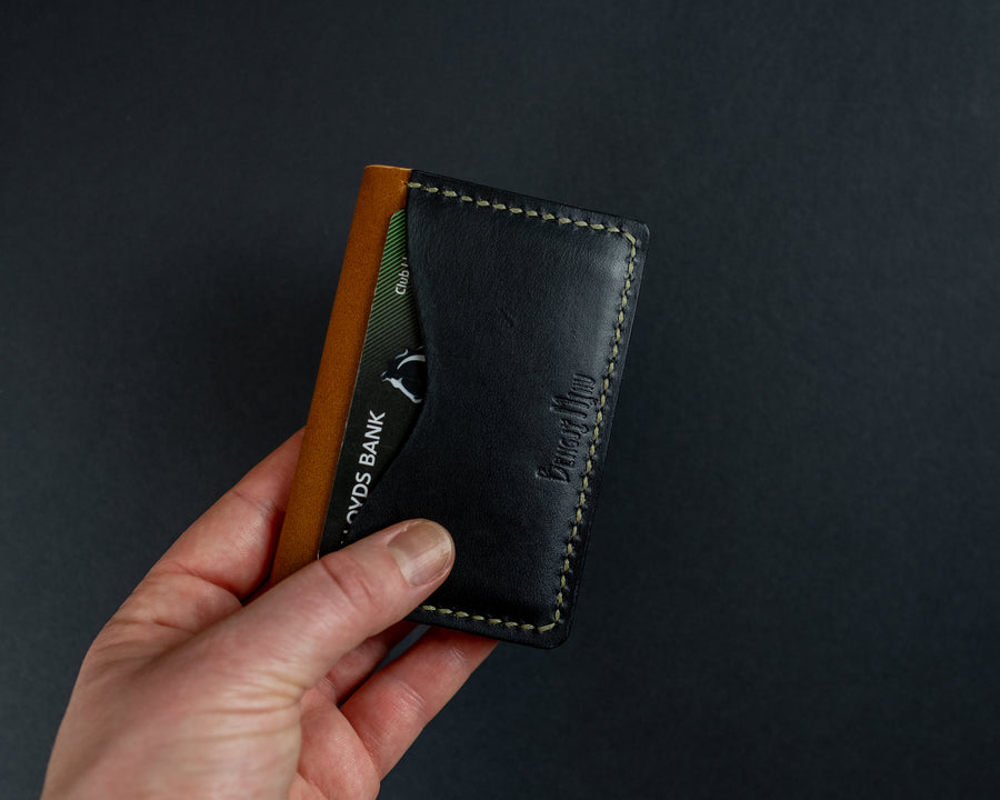 black and tan leather wallet with green thread
